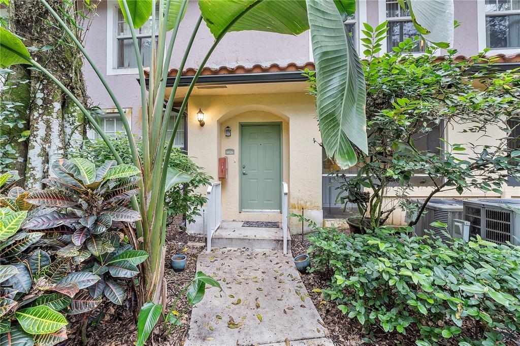 6926 West Sample Road, Unit 6926 Coral Springs, FL 33067 - Photo 2 of 41 a view of a house with a small yard plants and large tree