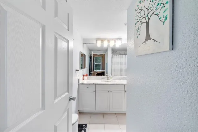 a bathroom with a granite countertop sink mirror vanity and toilet