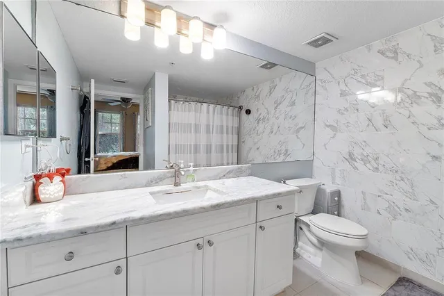 a bathroom with a granite countertop toilet sink and shower