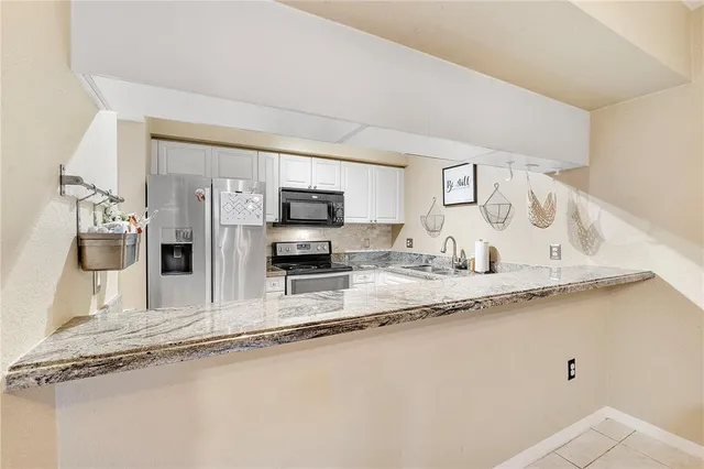 a kitchen with stainless steel appliances granite countertop a sink and a granite counter tops