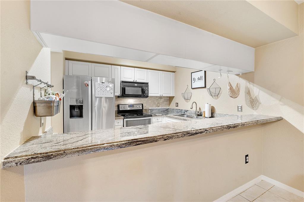 6926 West Sample Road, Unit 6926 Coral Springs, FL 33067 - Photo 9 of 41 a kitchen with stainless steel appliances granite countertop a sink and a granite counter tops