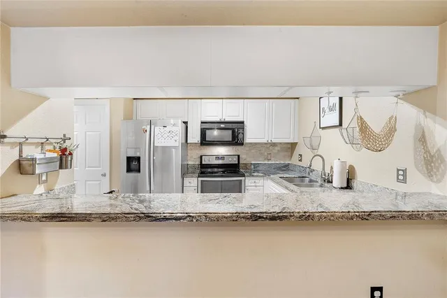 a kitchen with stainless steel appliances granite countertop a sink stove and granite counter top