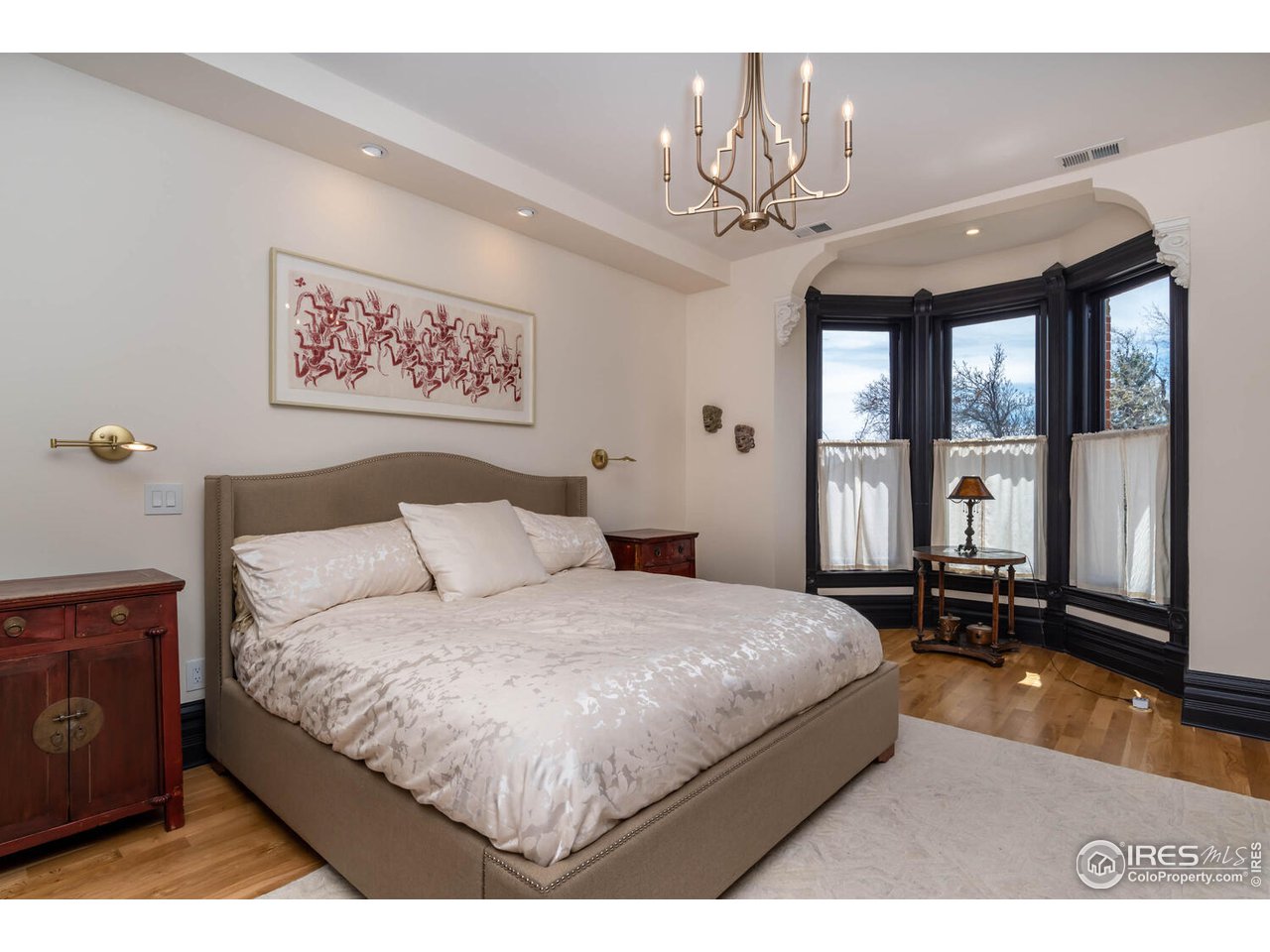 1507 Pine Street Boulder, CO 80302 - Photo 15 of 28 a bedroom with a large bed and a chandelier