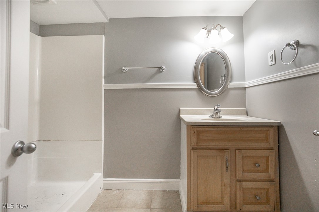 12328 Granger Road Cleveland, OH 44125 - Photo 29 of 37 Bathroom with a shower stall, vanity, and light tile patterned floors