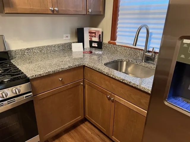a kitchen with granite countertop a sink and a stove top oven