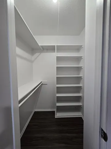 a view of walk in closet with empty racks
