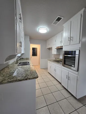 a large white kitchen with cabinets