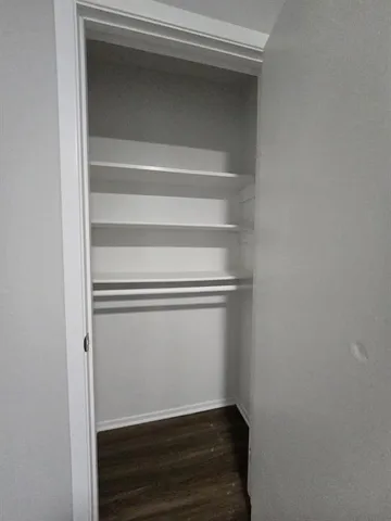 a view of walk in closet with empty racks