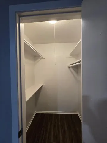 a view of walk in closet with empty racks