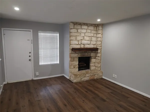 a view of empty room with wooden floor and fireplace