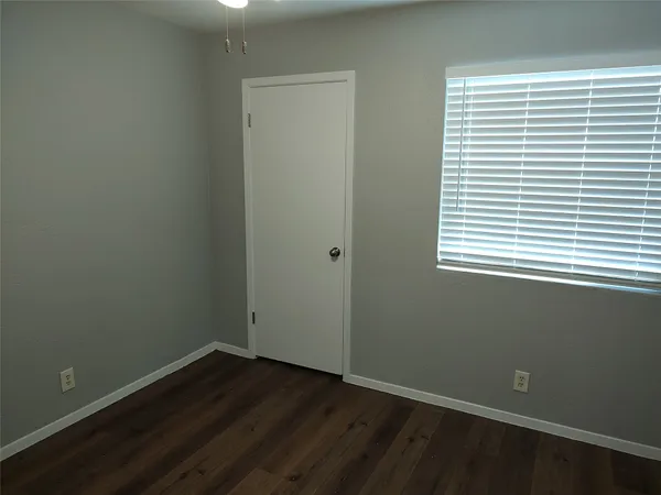 an empty room with wooden floor and a window