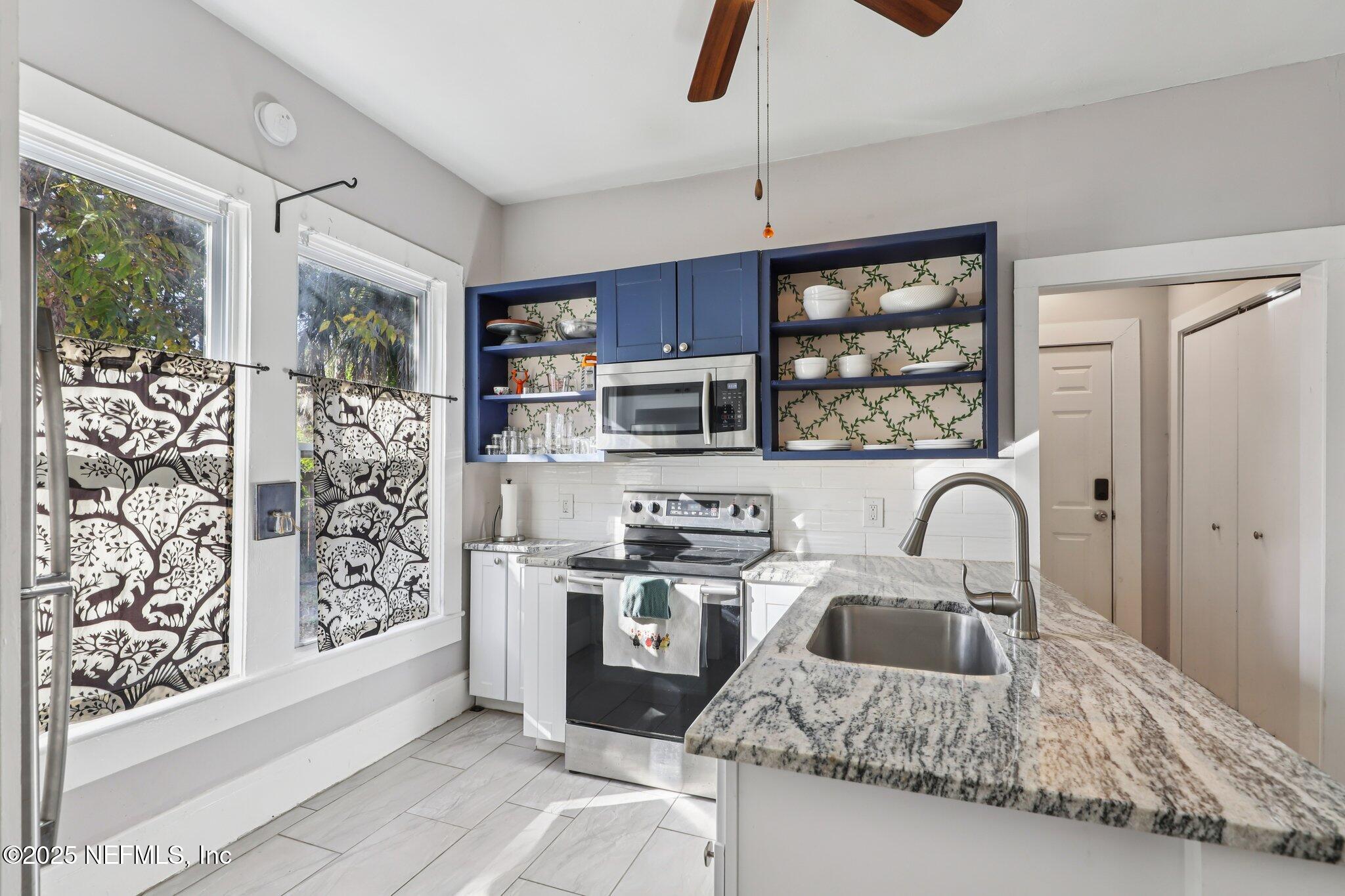 646 Day Avenue Jacksonville, FL 32205 - Photo 11 of 27 a kitchen with stainless steel appliances granite countertop a stove a sink and a refrigerator with wooden floor