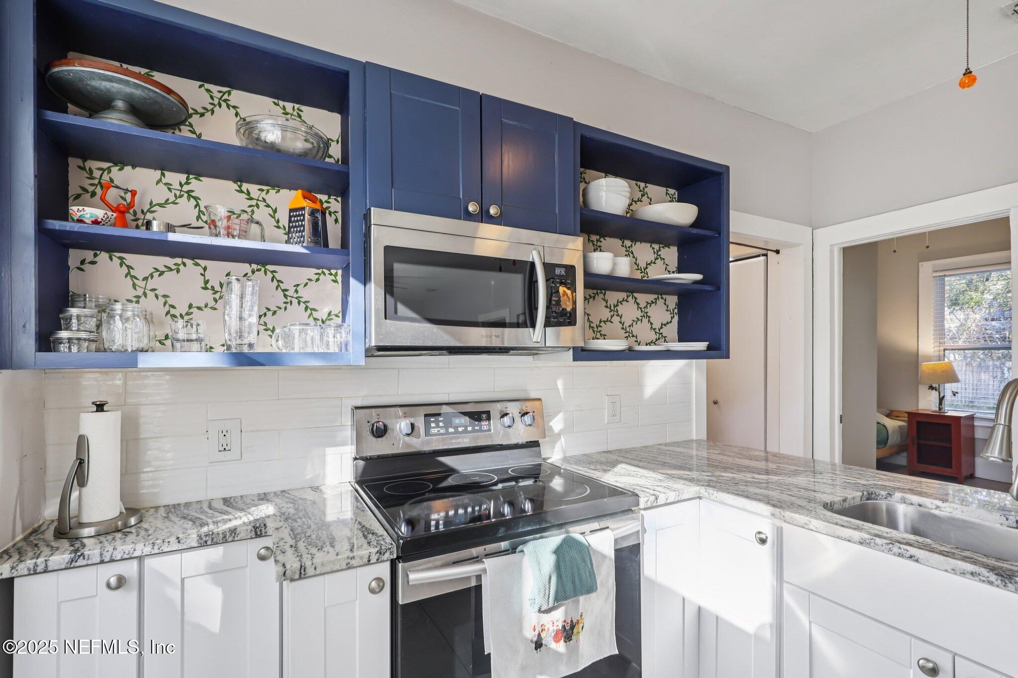 646 Day Avenue Jacksonville, FL 32205 - Photo 13 of 27 a kitchen with stainless steel appliances granite countertop a stove and a microwave