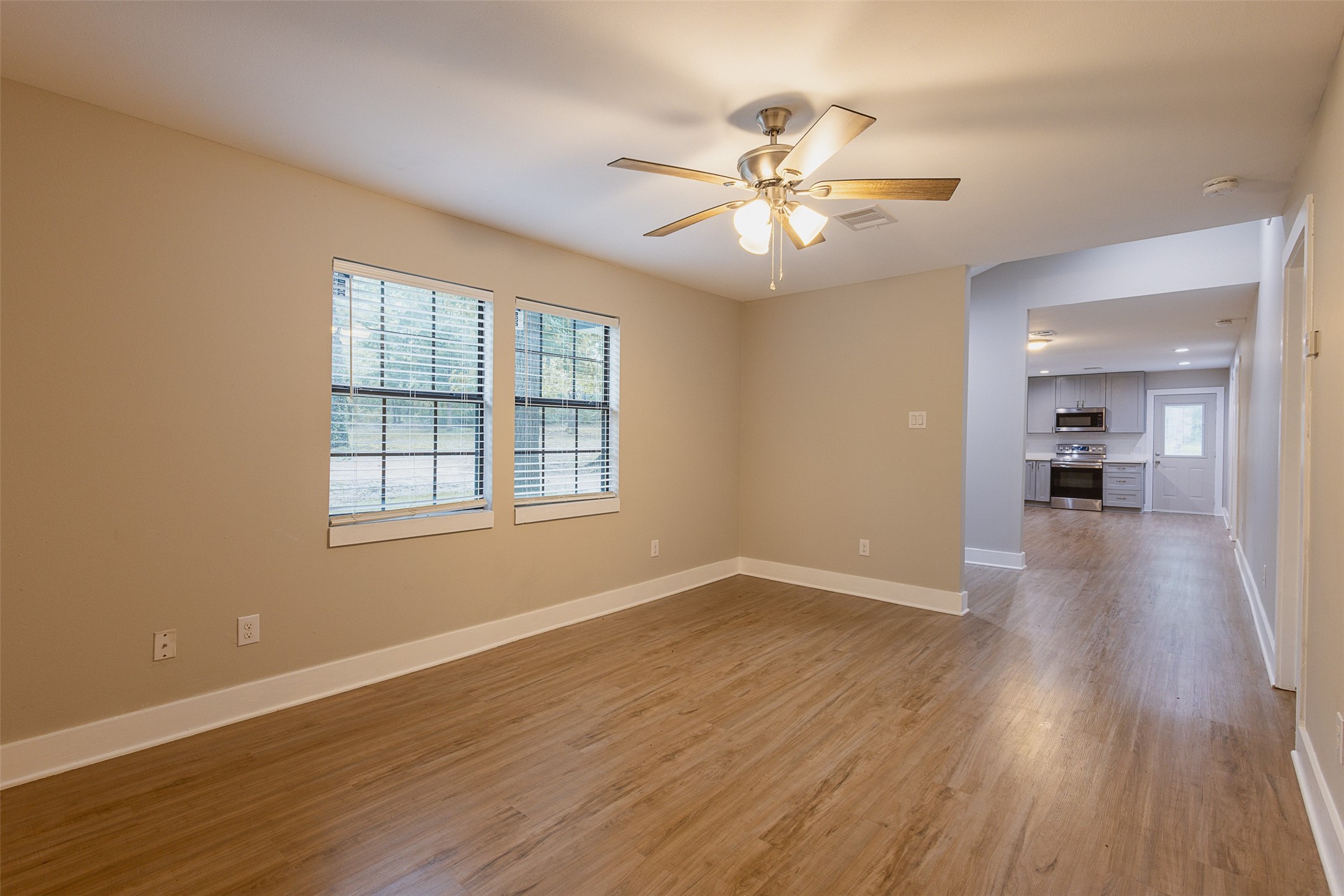 12028 Cedar Lane Conroe, TX 77303 - Photo 18 of 41 an empty room with wooden floor fan and windows