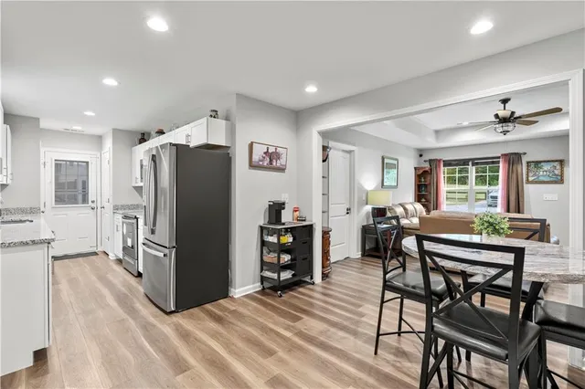 a kitchen with stainless steel appliances refrigerator dining table and chairs