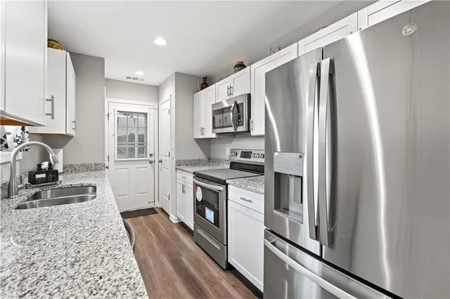 a kitchen with stainless steel appliances granite countertop a refrigerator stove and sink