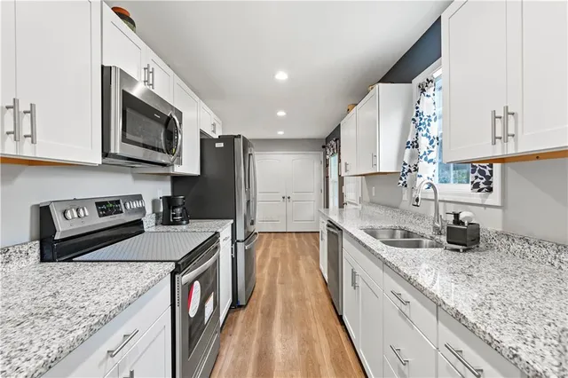 a kitchen with stainless steel appliances granite countertop a sink a stove top oven a counter space and cabinets