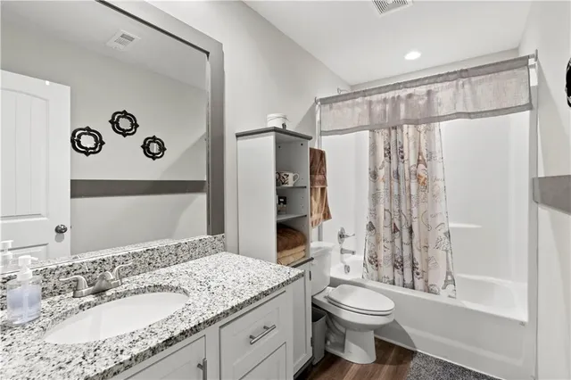 a bathroom with a granite countertop sink toilet and shower