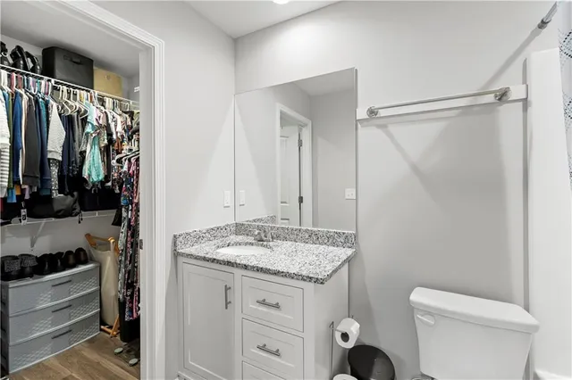 a bathroom with a granite countertop sink toilet and shower