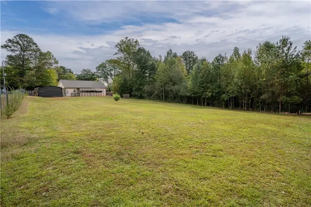 a view of a field with trees in the background