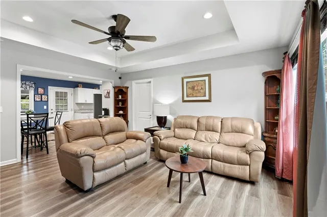 a living room with furniture and a ceiling fan