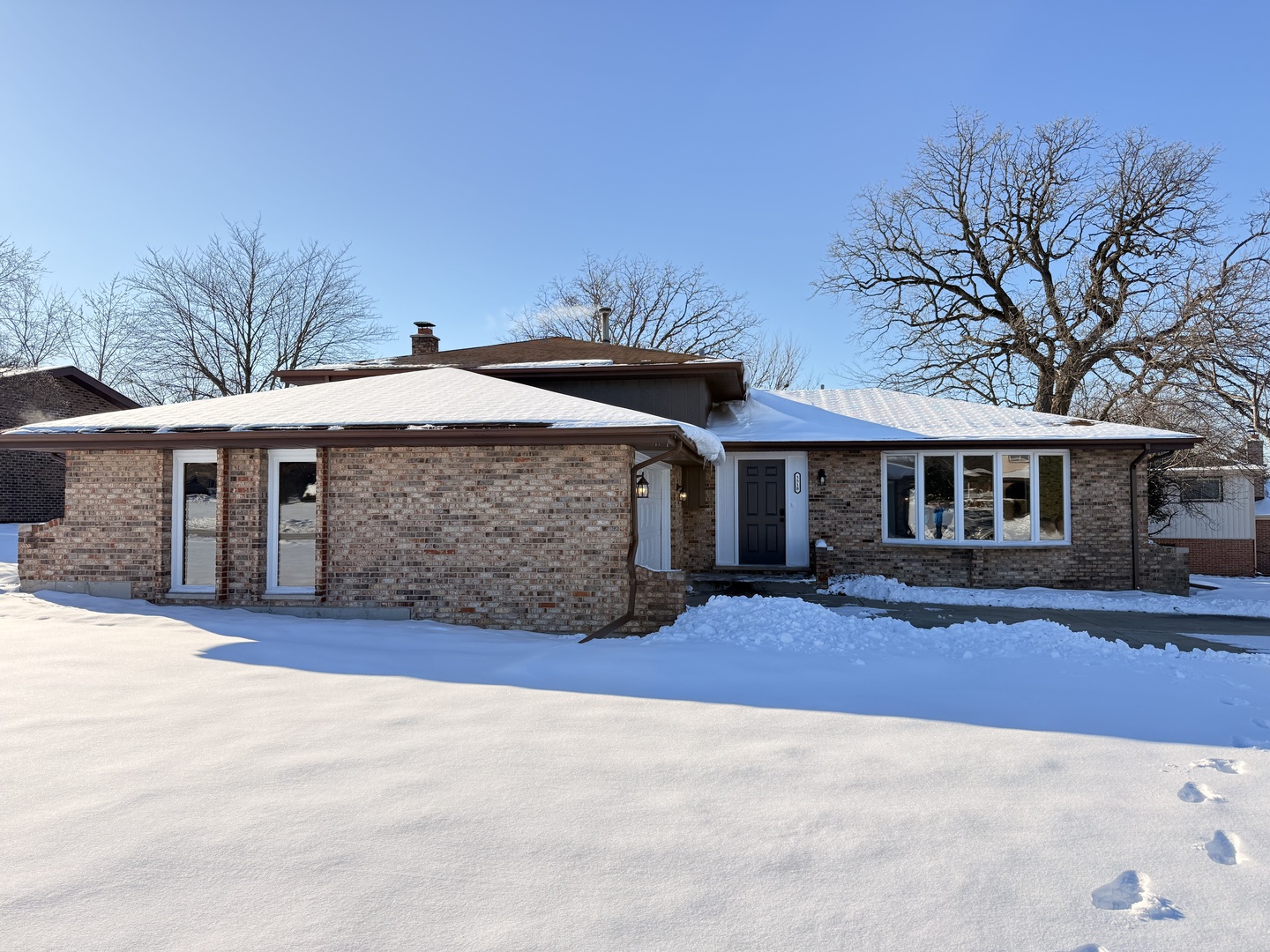 a front view of house with yard and trees in the background