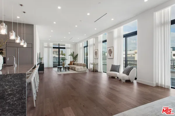 a living room with furniture wooden floor and a large window