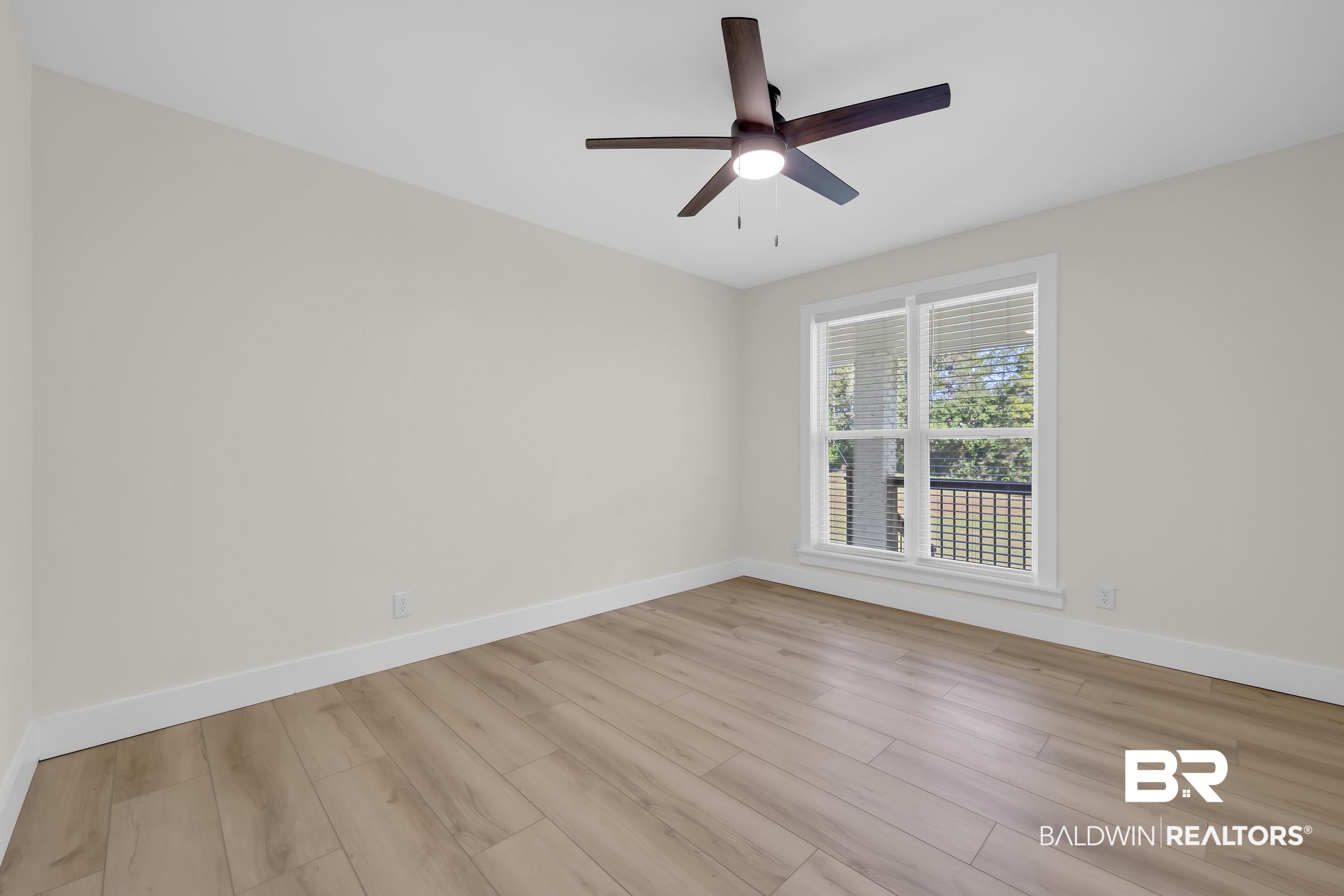 8170 Wilmer Georgetown Road Wilmer, AL 36587 - Photo 18 of 31 Bright room featuring wood-finish flooring, a contemporary ceiling fan with lighting, and a large window with white blinds and trim
