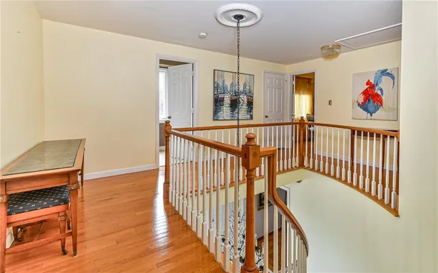 a view of hallway with wooden floor and chandelier