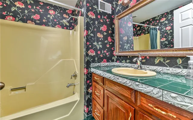 a bathroom with a granite countertop sink and a mirror