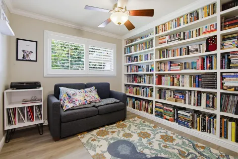 a living room with furniture and a book shelf