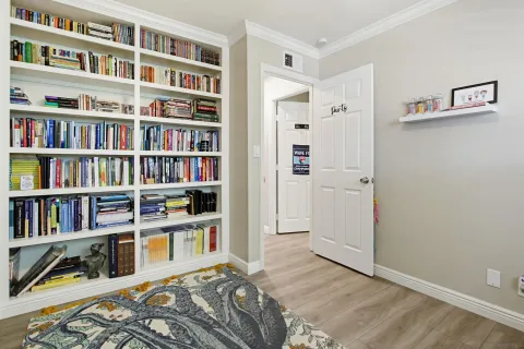 a bedroom with a bed and a book shelf