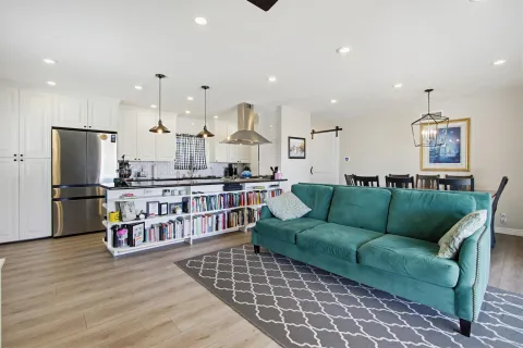 a living room with furniture kitchen view and a refrigerator