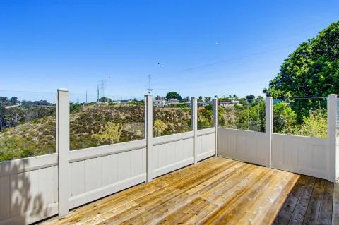 a house that has a big yard large trees with wooden fence