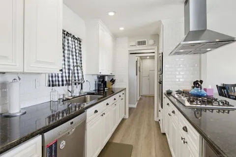 a kitchen with stainless steel appliances a sink stove and cabinets