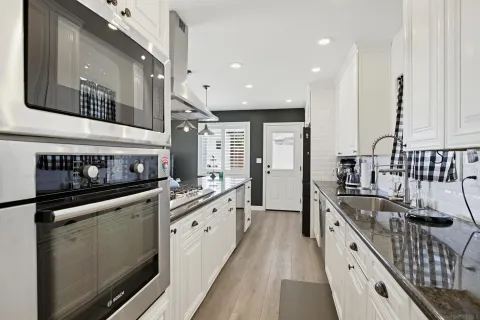a kitchen with stainless steel appliances granite countertop a stove a sink and a refrigerator