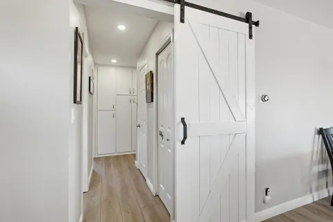 a view of a hallway with wooden floor and staircase