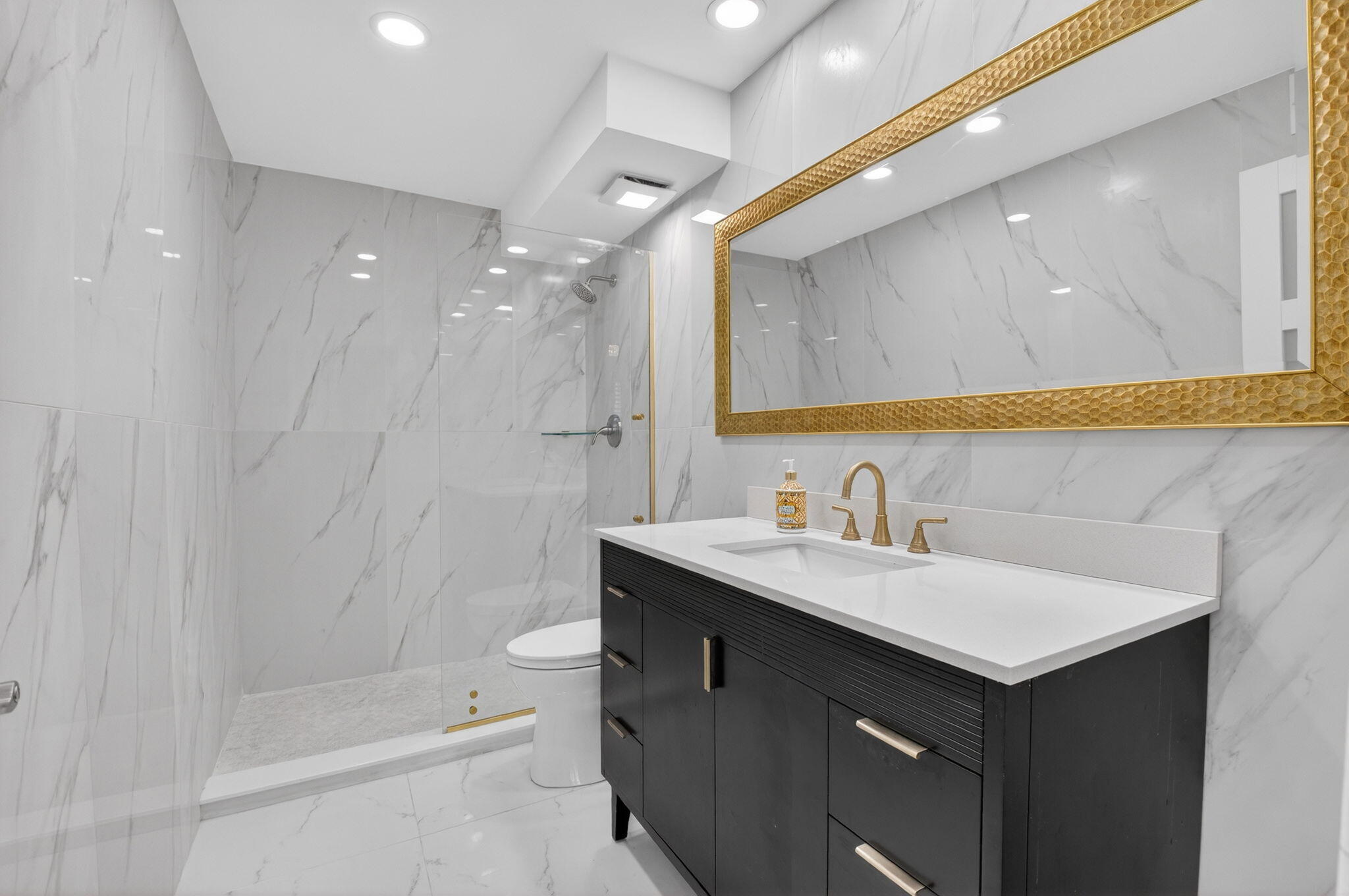 7738 Lakeside Boulevard, Unit 352 Boca Raton, FL 33434 - Photo 14 of 60 a bathroom with a sink a toilet a mirror and shower