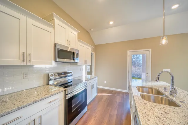 a kitchen with stainless steel appliances granite countertop a stove and a refrigerator