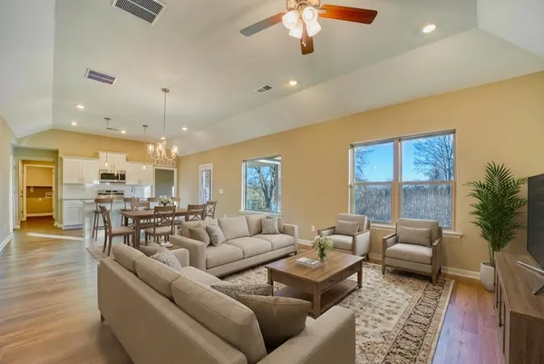 a living room with furniture and a chandelier