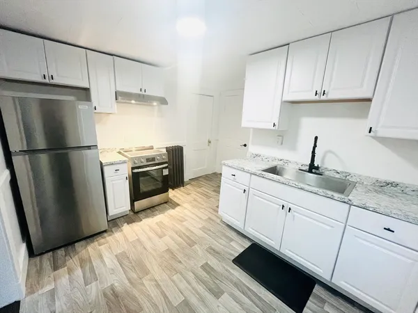 a kitchen with granite countertop white cabinets and stainless steel appliances