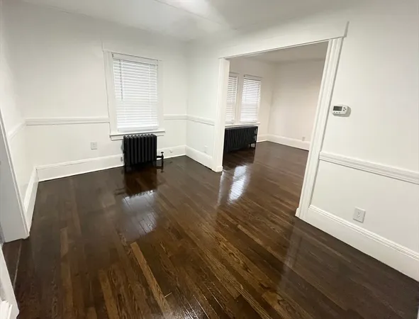 a view of empty room with wooden floor