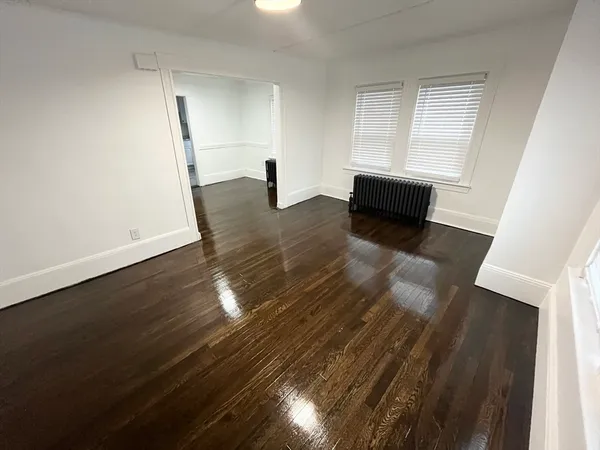a view of empty room with wooden floor