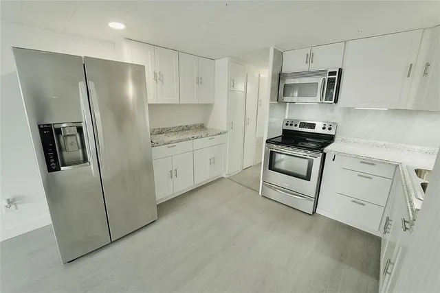 a kitchen with stainless steel appliances a refrigerator sink and stove