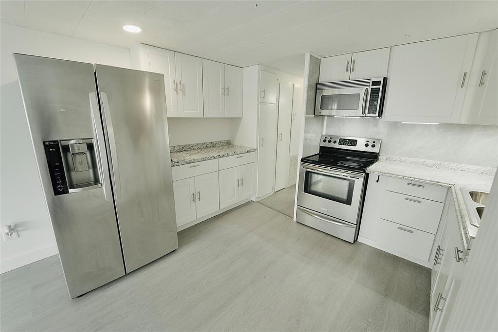 a kitchen with stainless steel appliances a refrigerator sink and stove