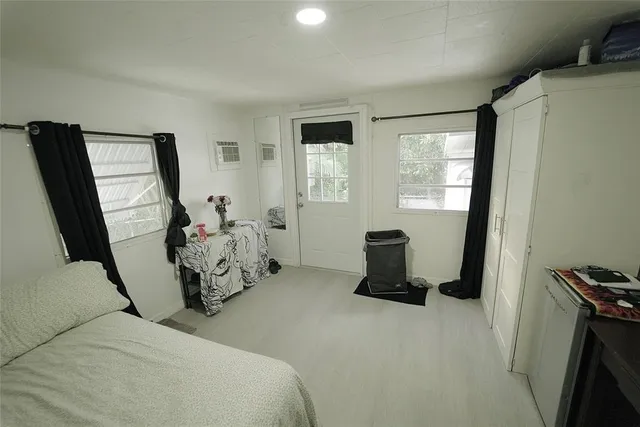a room with lots of white furniture and a shower