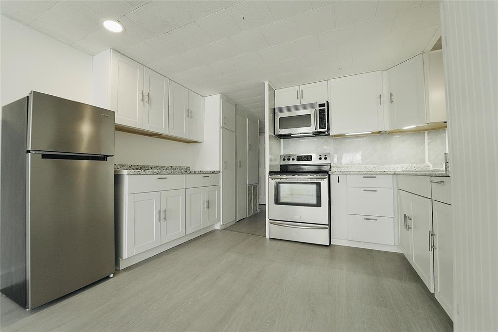 8520 Southwest 18th Court Davie, FL 33324 - Photo 22 of 48 a kitchen with white cabinets and stainless steel appliances