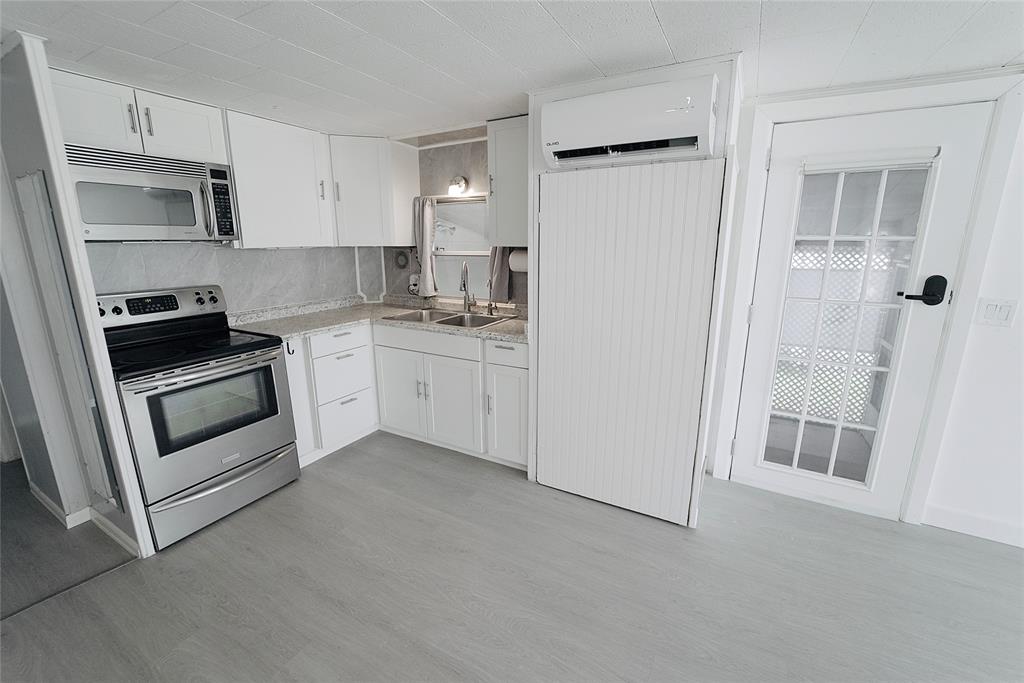 8520 Southwest 18th Court Davie, FL 33324 - Photo 30 of 48 a kitchen with cabinets and white appliances