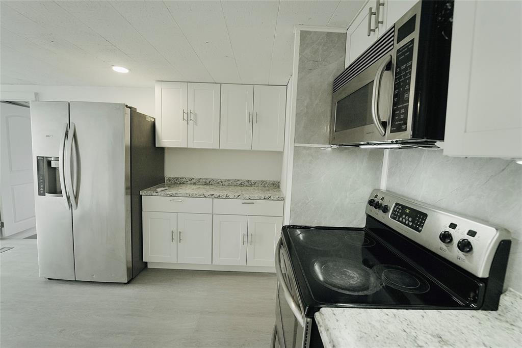 8520 Southwest 18th Court Davie, FL 33324 - Photo 7 of 48 a kitchen with a stove and a microwave