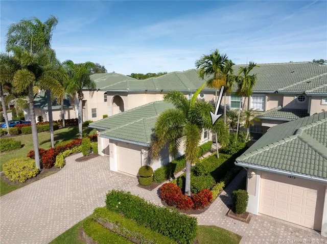 a front view of a house with a yard and potted plants